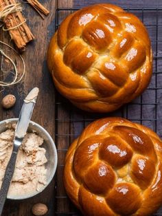 two hot cross buns sitting on top of a cooling rack next to cinnamon sticks