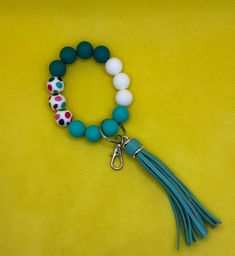 a bracelet with beads and tassels on a yellow background