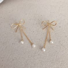 * DETAILS * - Shiny Gold Plated Ribbon Bow Earrings 17*13mm - Freshwater Round Pearls 4mm - Gold Plated Chain 🌟more ribbon earrings. Here is the link. https://www.etsy.com/JinnysJewelryBySeJin/listing/986389259/delicate-ribbon-bow-earrings-lovely?utm_source=Copy&utm_medium=ListingManager&utm_campaign=Share&utm_term=so.lmsm&share_time=1616484697112 https://www.etsy.com/JinnysJewelryBySeJin/listing/983085149/ribbon-teardrop-dangle-earrings-bridal?utm_source=Copy&utm_medium=Lis Bow Pearl Earrings, Cute Dangle Earrings, Ribbon Earrings, Bridesmaids Earrings, Bridesmaids Jewelry, Christmas Gift Basket Ideas, Pretty Jewelry Necklaces