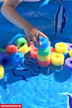 a young child playing with toys in a pool