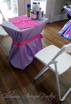 a purple table with pink polka dots on it and two white chairs next to it