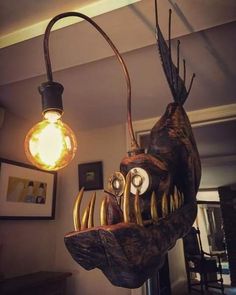 a lamp that looks like a fish head hanging from the ceiling in a living room