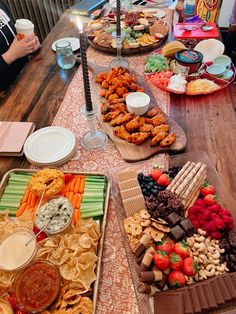 a table filled with lots of food on top of a wooden table covered in plates and bowls