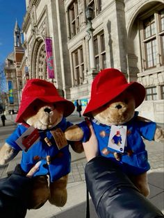 two teddy bears dressed in red hats and blue shirts