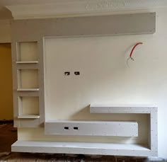 an empty room with some shelves on the wall