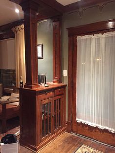 a living room with wooden furniture and curtains