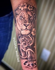 a lion and cub tattoo on the arm