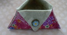 an origami flowered purse with a button on it