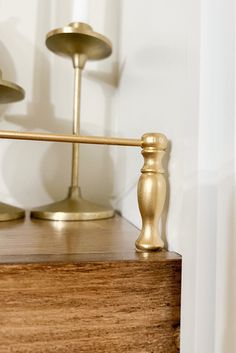 two brass candlesticks sitting on top of a wooden table