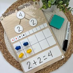 a wooden board with numbers and numerals on it next to a potted plant