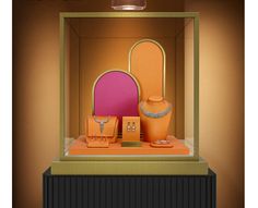 an orange and pink display case with jewelry in it