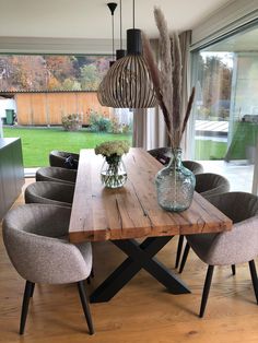 a wooden table surrounded by grey chairs