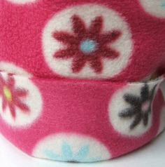 a pink and white hat with flowers on it