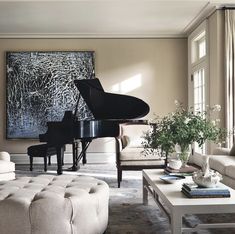 a living room filled with furniture and a piano in front of a large painting on the wall