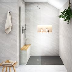 a white tiled bathroom with wooden stools and plants in the shower stall, along with two towels hanging on the wall