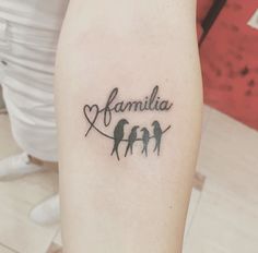 a small tattoo with three birds on it's arm and the word familia written in cursive font