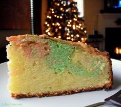 a piece of cake sitting on top of a white plate next to a christmas tree