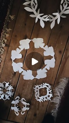 paper cut wreaths are arranged on a wooden surface