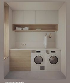 a washer and dryer in a small room with cabinets on the wall behind them