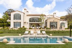 a large house with a swimming pool in the front yard and lawn area next to it