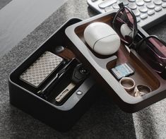 a desk with a keyboard, sunglasses and other items