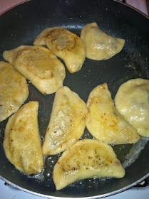 some dumplings are cooking in a pan on the stove top and being stirred with water