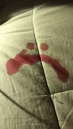 a bed with red stains on the sheets