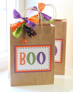 two brown paper bags with halloween decorations on the front and one has boo written on it