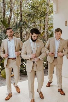 three men in tan suits are walking together