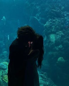 two people standing in front of an aquarium