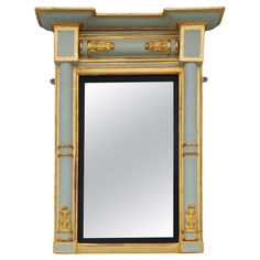 an ornate mirror with gold trimmings and blue paint on the front, against a white background