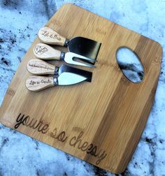 a cutting board with three knives on it that says, you're so cheese