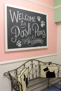 a welcome to posh paws dog grooming sign hangs on the wall next to a wrought iron bench