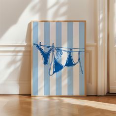 a blue and white striped wall with two clothes hanging on a line