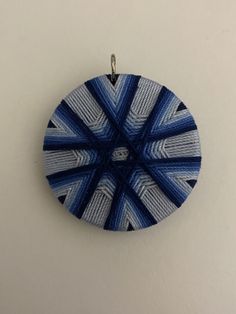 a blue and white circular ornament hanging on a wall