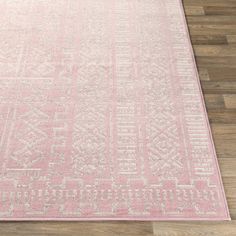 a pink rug with an intricate design on the top and bottom, sitting on a wooden floor