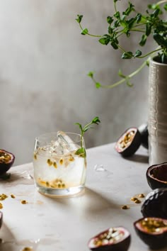 a glass filled with ice and garnish sitting on top of a white table