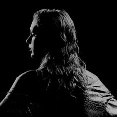 a black and white photo of a woman with long hair looking off into the distance