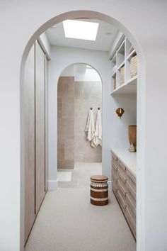 an image of a hallway with white walls and beige furniture on the other side, there is