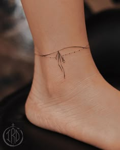 a woman's foot with a small tattoo on the side of her left ankle