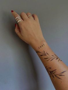 a woman's hand with a small bamboo tattoo on her left arm and wrist