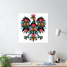 a colorful bird on a white wall above a desk with a potted plant in the foreground