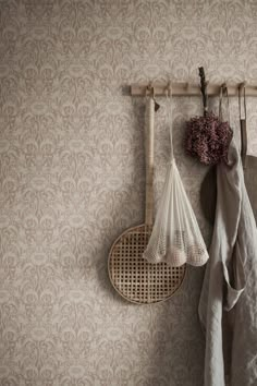 two wooden rackets hanging on a wall next to a vase with flowers in it