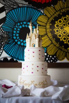 a white wedding cake with pink and gold decorations