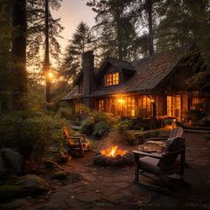 a house with a fire pit in front of it at sunset or dawn, surrounded by trees and bushes