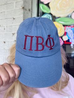 a woman wearing a blue hat with the letters pibo embroidered on it's side