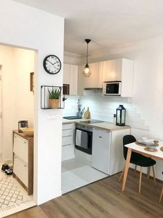 a kitchen with white walls and wooden floors