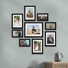 a bunch of pictures hanging on the wall in front of a table with a coffee pot