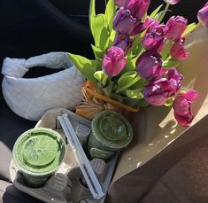 the flowers are sitting in the car next to some jars and containers with dips