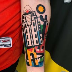 a person with a tattoo on their arm that has an image of a city in it